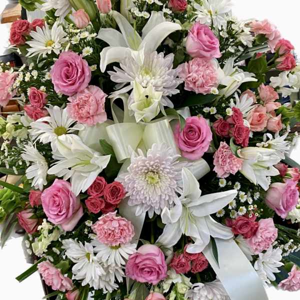 Pink and white mixed flower arrangement with lilies, roses, and daisies