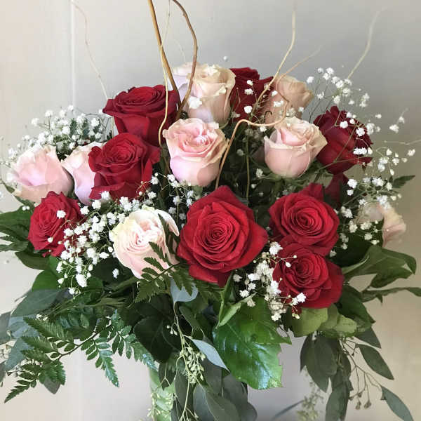 Bouquet of red and pale pink roses in a glass vase