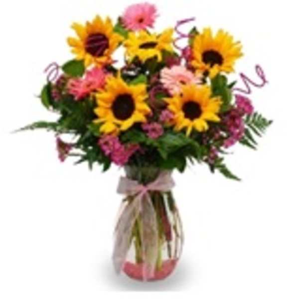 Bouquet of sunflowers and pink flowers in a glass vase
