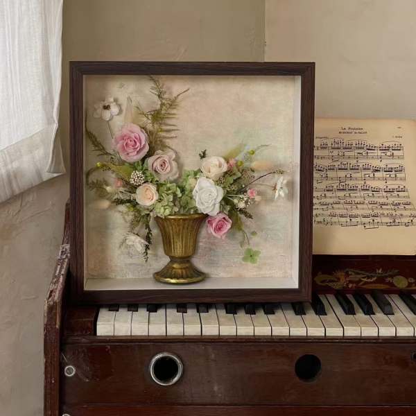 Framed floral arrangement with pink and white roses in a gold vase
