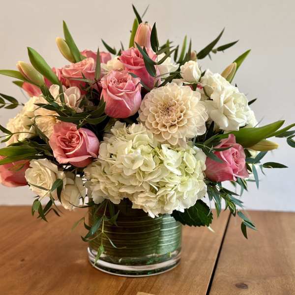 Pink roses and white hydrangeas arranged in a glass vase