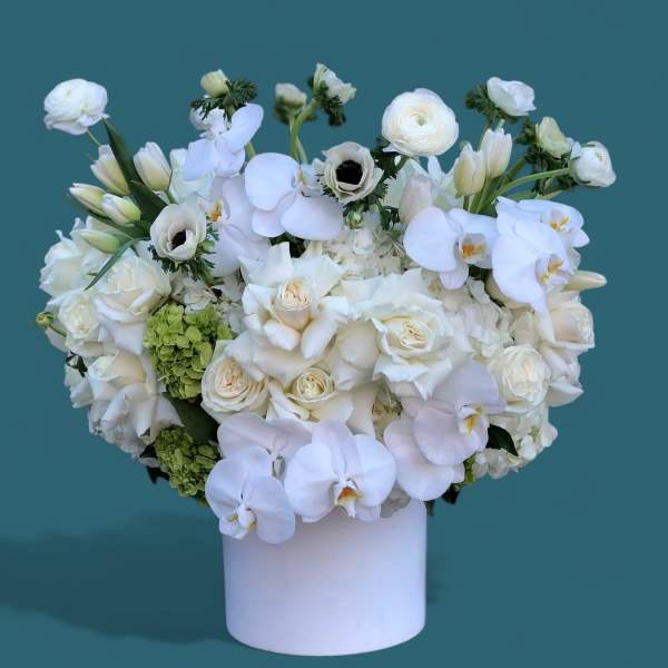 White floral arrangement in a white cylindrical vase
