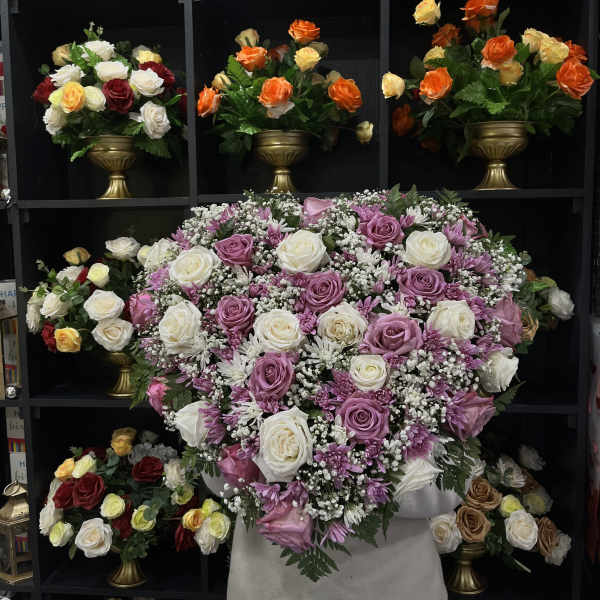 Large bouquet of pink and white roses with purple daisies