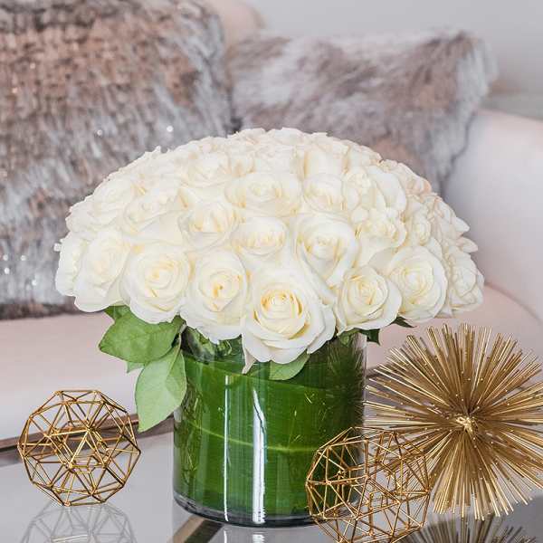 White rose bouquet in a green glass vase with gold decor