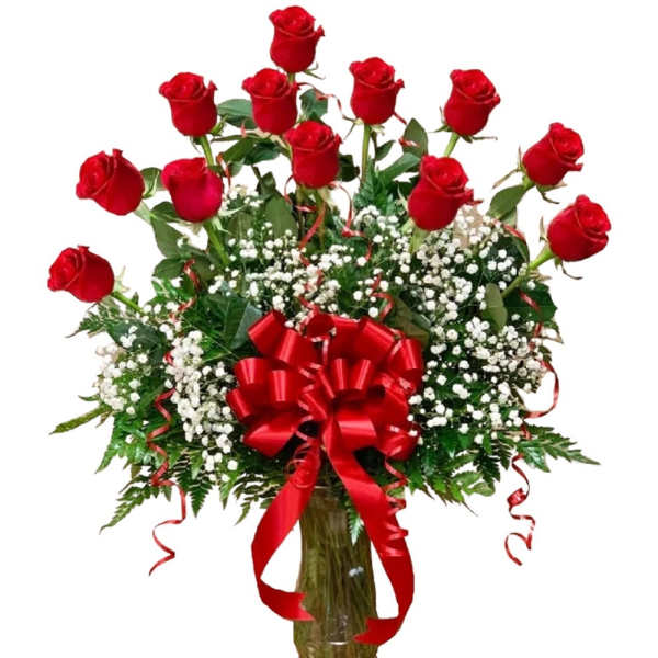 Bouquet of red roses with baby's breath in a glass vase and red ribbon