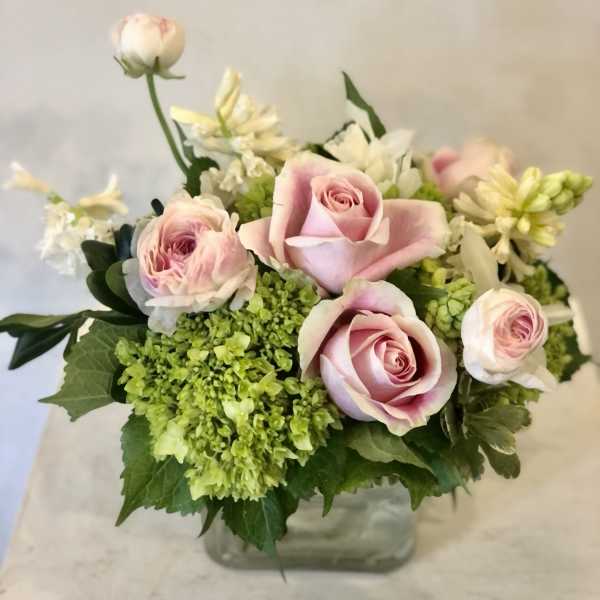 Pink roses and green hydrangeas in a glass vase
