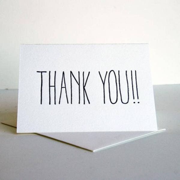 White thank-you card with black lettering on a table
