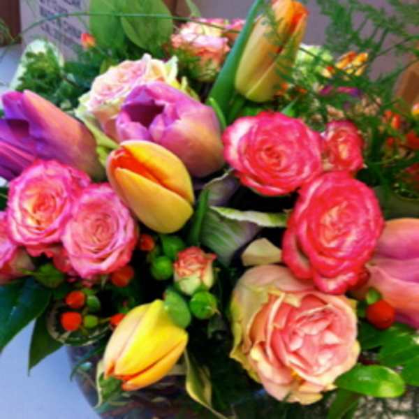 Bouquet of pink and yellow tulips with pink roses in a vase