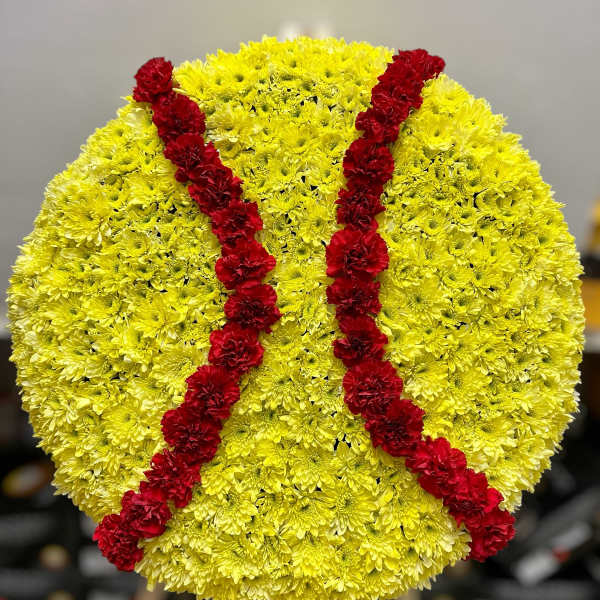 Round yellow floral standing spray shaped like a softball with red stitching lines