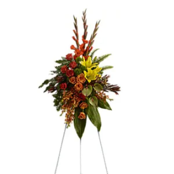 Standing floral spray with red, yellow, and orange flowers on a metal easel