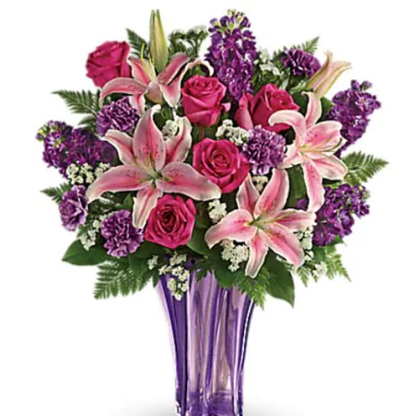 Pink roses and lilies arranged in a purple vase