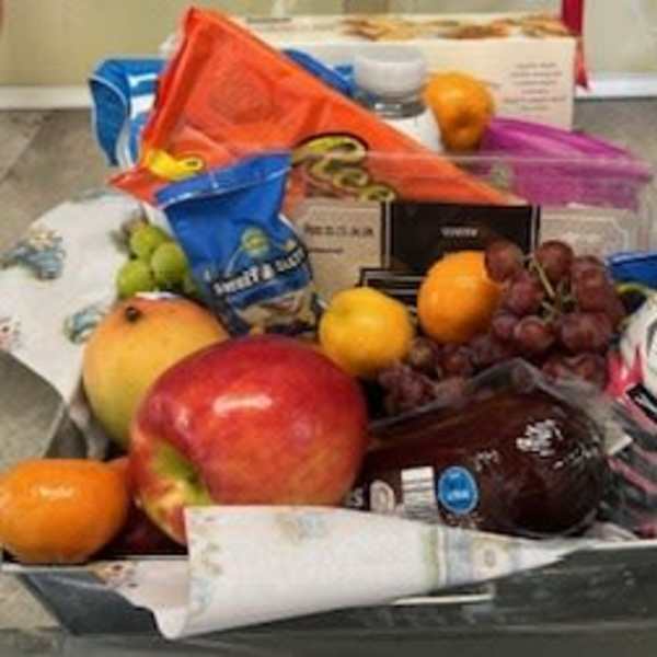 Gift basket with assorted fruit and packaged snacks