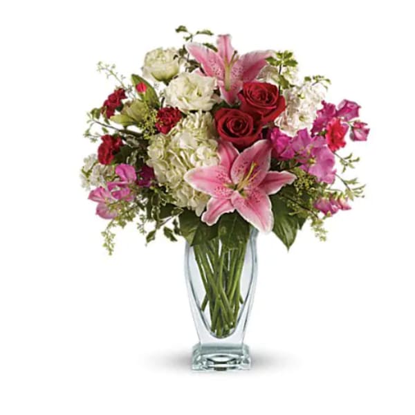 Pink lilies and red roses in a clear glass vase