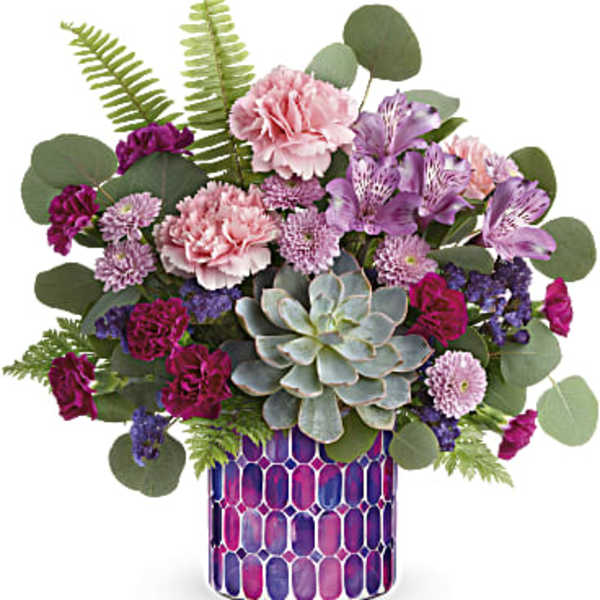 Mixed pink and purple bouquet in a patterned vase with a succulent centerpiece