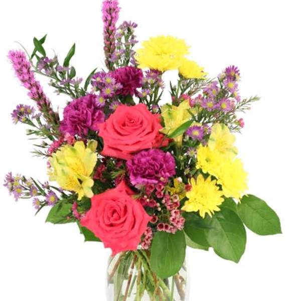 Mixed bouquet of pink roses, yellow daisies, and purple flowers in a glass vase