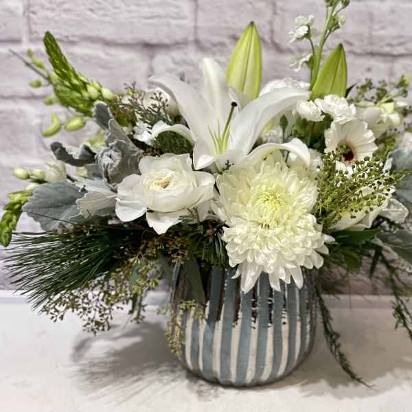 White floral arrangement in a striped ceramic vase
