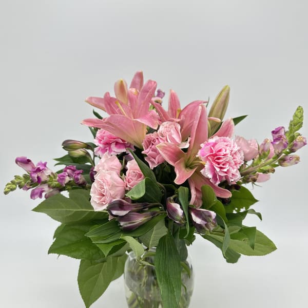 Pink lilies and carnations in a clear glass vase