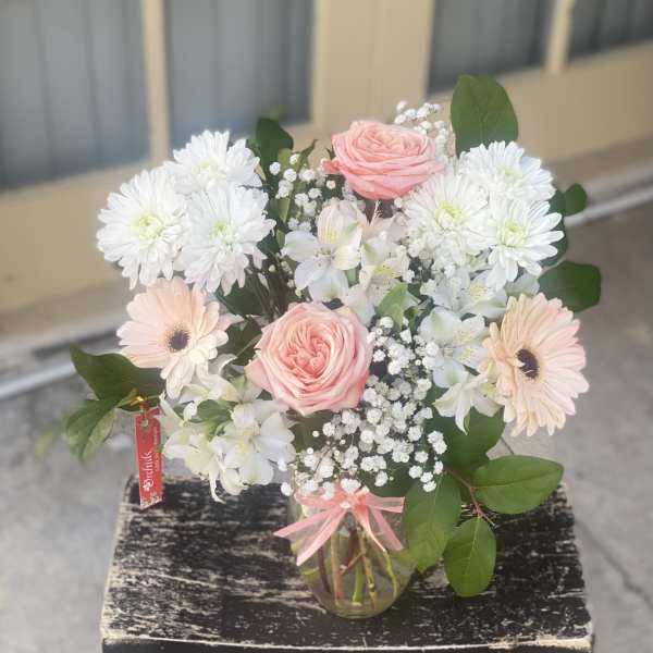 Pink roses and white daisies in a glass vase
