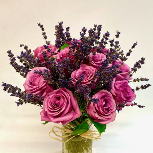 Pink roses with purple filler flowers in a glass vase
