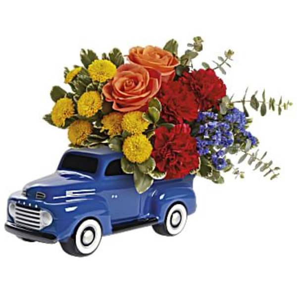 Blue vintage truck filled with colorful flowers