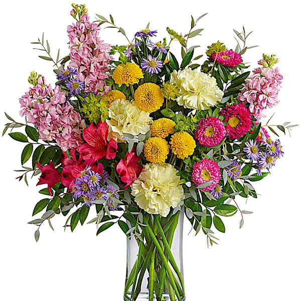Mixed bouquet of pink, yellow, purple, and white flowers in a clear glass vase