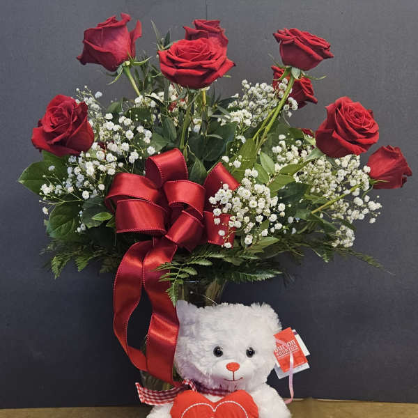 Red roses with baby's breath and a teddy bear holding a heart