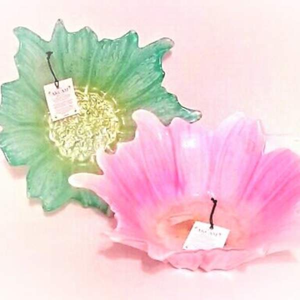 Two decorative glass flower-shaped bowls, one green and one pink