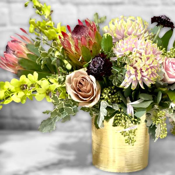 Mixed bouquet in a gold vase with pink and green flowers