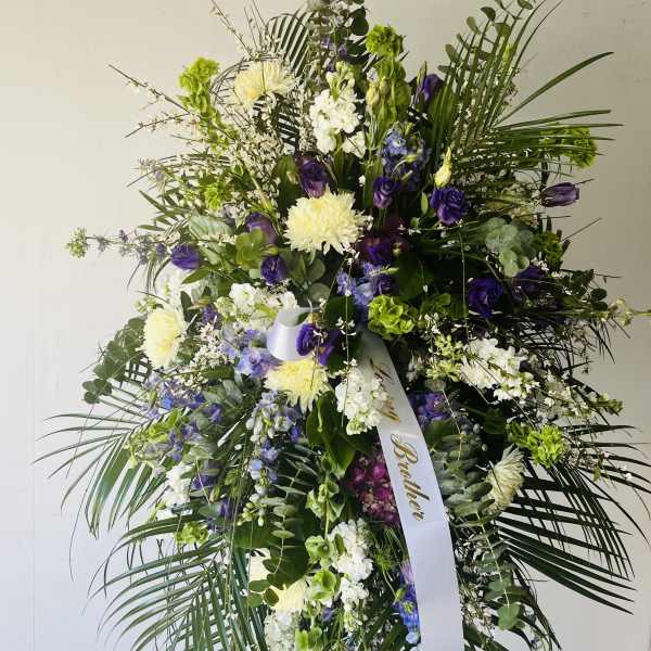 Tall standing floral spray with purple, white, and green blooms