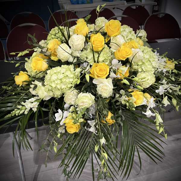 Yellow and white rose arrangement with hydrangeas and greenery