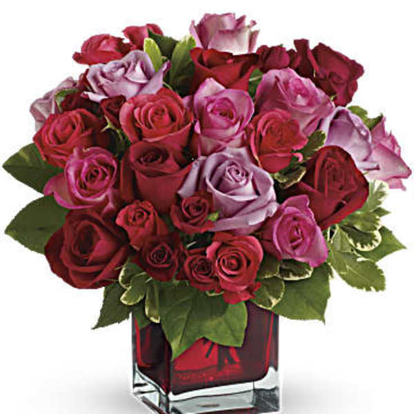 Bouquet of red and pink roses in a square glass vase