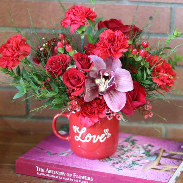 Red floral arrangement in a mug with "Love" text