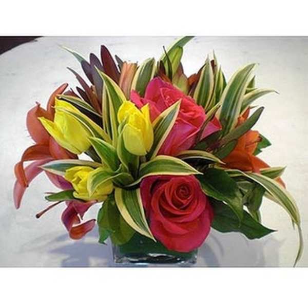 Colorful bouquet of roses and tulips in a glass vase