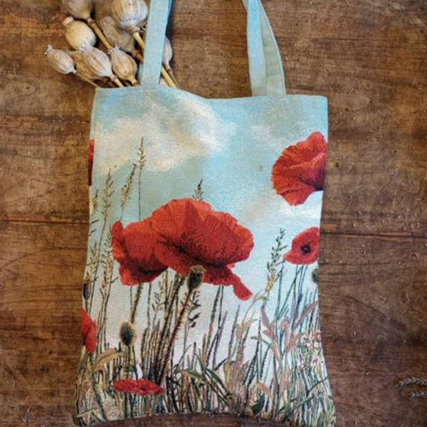 Tote bag with red poppy print and dried seed pods tucked in the handle