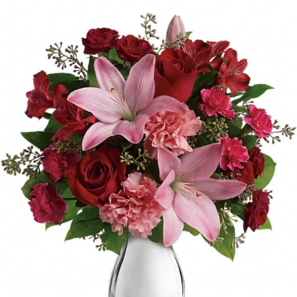 Pink lilies and red roses in a clear glass vase