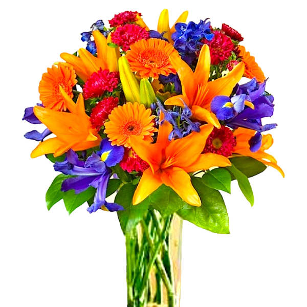 Bouquet of orange lilies, purple irises, and red flowers in a glass vase