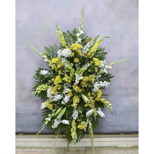 Large standing floral spray with yellow and white flowers on an easel