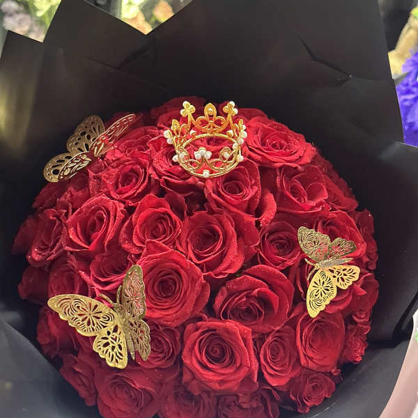 Bouquet of red roses wrapped in black paper with gold butterfly accents