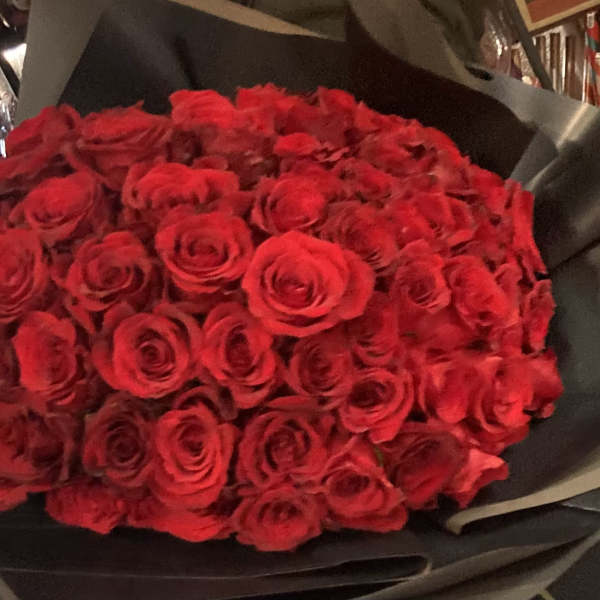 Large bouquet of red roses wrapped in black paper