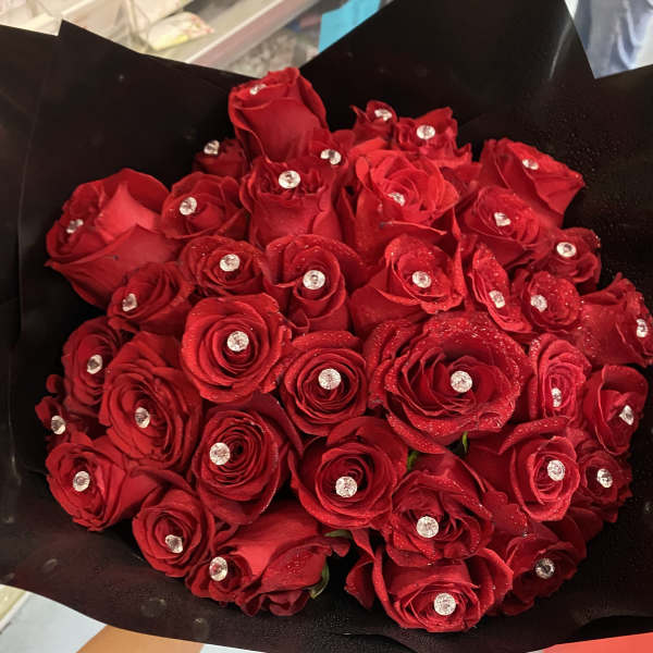Bouquet of red roses with clear gem accents wrapped in black paper