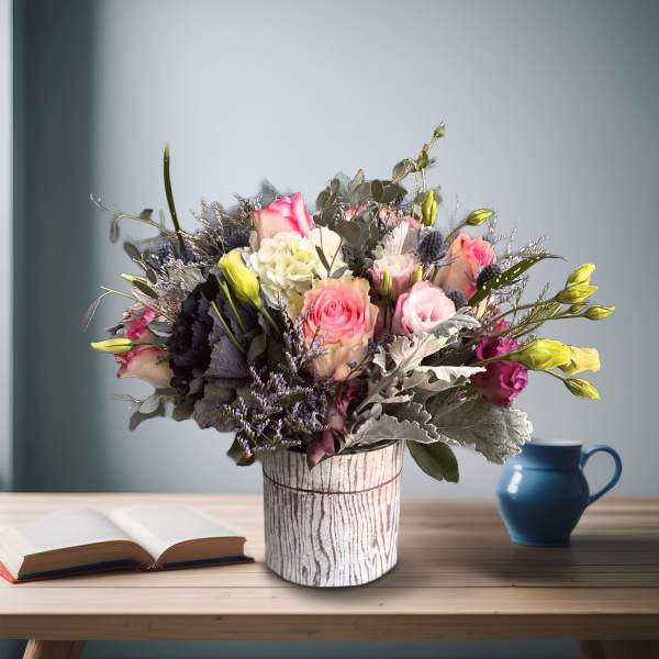 Mixed bouquet of pink and white flowers in a rustic vase