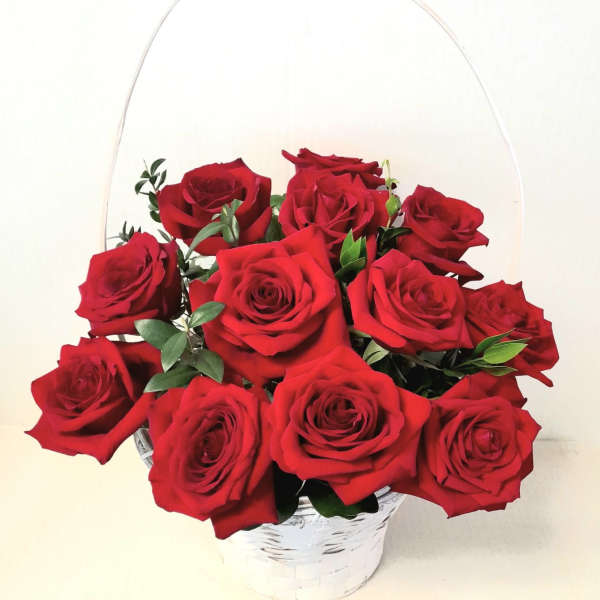 Basket of red roses with greenery