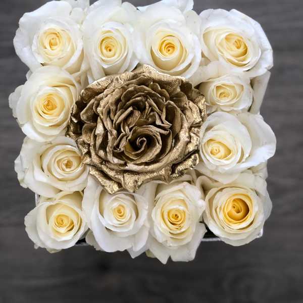 White roses surrounding a metallic gold rose centerpiece