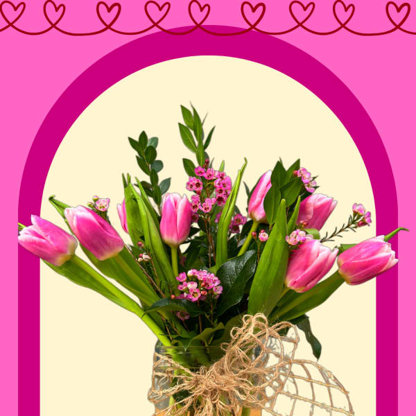 Pink tulips in a glass vase with a twine bow