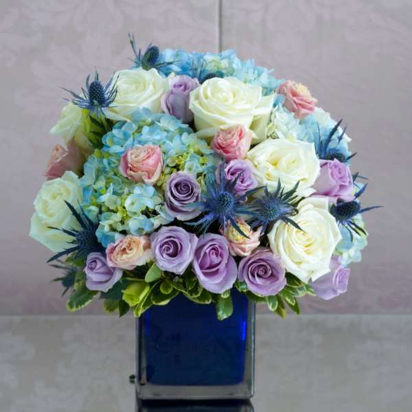 Bouquet of pastel roses and hydrangeas in a blue vase