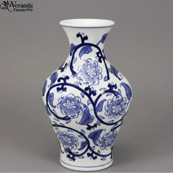 White ceramic vase with blue floral pattern and curved silhouette on a gray background
