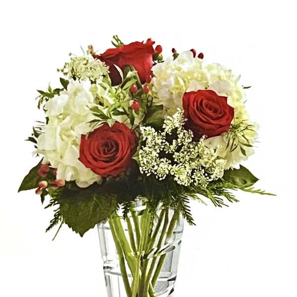 Red roses and white hydrangeas in a clear glass vase