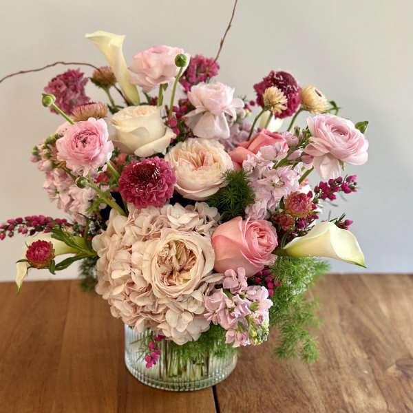 Pink and cream floral arrangement in a glass vase