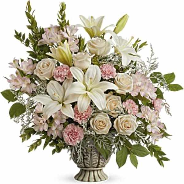 Bouquet of white lilies, cream roses, and pink carnations in a decorative vase