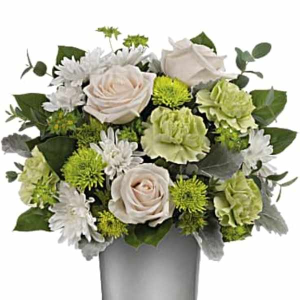 White roses and green carnations in a glass vase